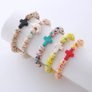 Set of four cross charm beaded bracelets with natural turquoise and wood beads on display