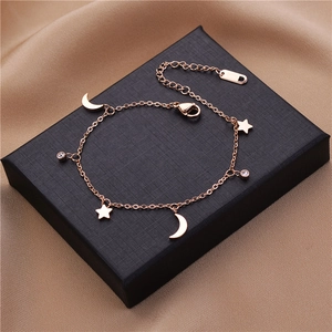 Detail eines Roségold-Armbands mit Stern und Mond und Karabinerverschluss auf Seide