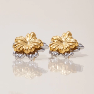Detailed macro shot of two-tone flower stud earrings in gold and silver stainless steel