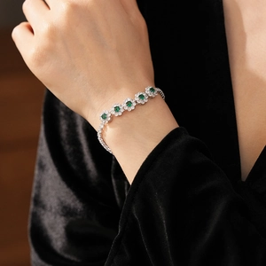 Vue macro du bracelet à pendentif fleur avec zircons verts sur le poignet