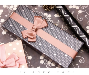 Elegant gift boxes with pink silk ribbons and geometric wrapping paper for birthday