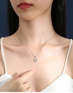Close-up of D color moissanite pendant on a silver S925 sterling chain worn by a model