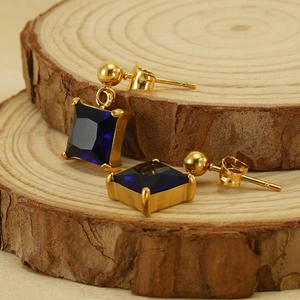 18K gold plated earrings featuring square deep blue zircon on rustic wooden stand