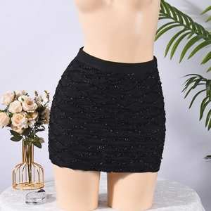 Détail d'une mini-jupe noire à texture ondulée ornée de paillettes et taille élastique