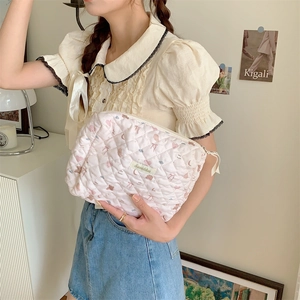 Détail de la trousse de toilette rose matelassée aux motifs mignons en situation réelle