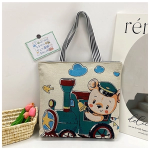 Detail of cartoon bear on locomotive print with striped straps on canvas tote bag