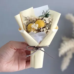 Detailed view of mini dried flower bouquet with yellow craspedia and white baby breath