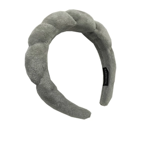 Detail of grey plush twisted headband featuring a black handmade textile label inside