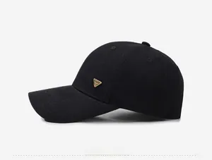 Side view of black baseball cap with golden triangle metal logo and textured fabric