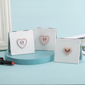 Three mini PU leather compact mirrors with heart pearl accents and bow details