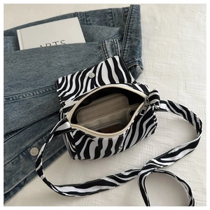 Detail of zebra print crossbody bag showing spacious interior for phone and wallet