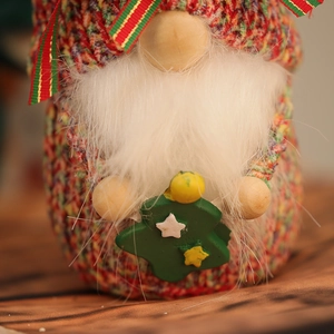 Detail of a Christmas gnome featuring a red and green knit hat and plush white beard