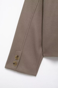 Detail view of brown wool coat sleeve featuring side slit and two decorative round buttons