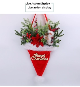 Close-up of lighted Christmas hat wall hanging with pine needles and Santa doll
