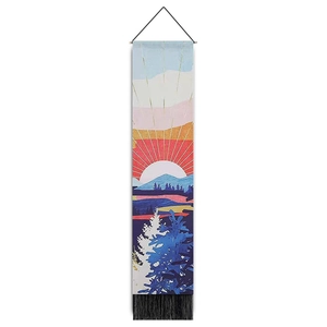 Detailed view of tapestry featuring sunrise landscape, mountain art, and black tassels