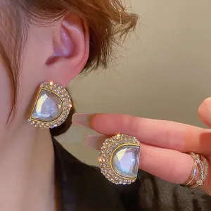 Boucles d'oreilles dorées en forme d'éventail avec pavé de cristaux et pierre centrale