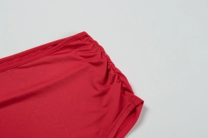 Detail of red ruched dress fabric with high-elastic texture and precision stitching