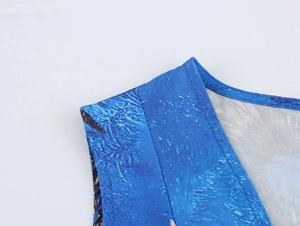 Dettaglio ravvicinato dello scollo a V con stampa floreale blu e cuciture sulla spalla