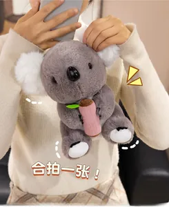 Close-up of a cute plush koala toy with pink bamboo detail held by a female model