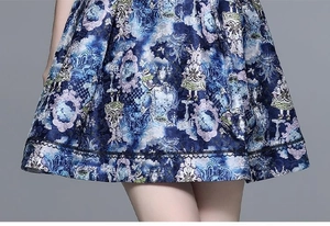 Detailed close-up of blue tweed dress hem with rabbit print and black wave lace trim