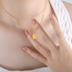 18K gold-plated titanium steel necklace with 'Good Luck' oval pendant on a model