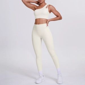 Detail of one-shoulder yoga sports bra and high-waisted leggings in creamy white fabric