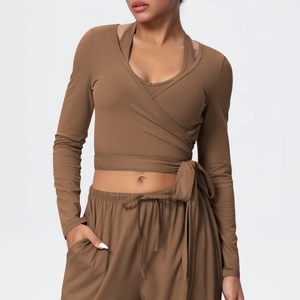 Detail of cross-wrap long sleeve yoga top with side tie in matte brown fabric
