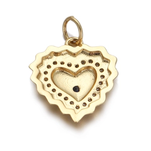 Detail of a gold heart charm with a blue evil eye stone and textured finish