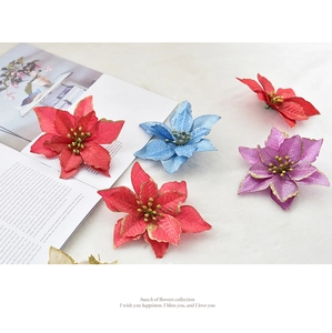 Close-up of 13cm sparkling artificial poinsettia flowers with gold glitter for Christmas decor