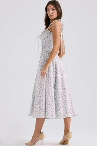 Close-up of white midi dress featuring purple floral patterns and neck-tie design