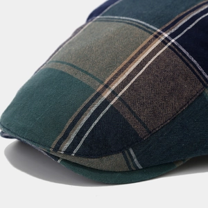 Close-up of vintage plaid ivy cap showing multi-color woven texture and stitch detail