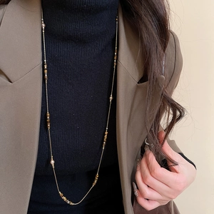 Tiger eye and pearl long necklace on model with vintage brown blazer aesthetic
