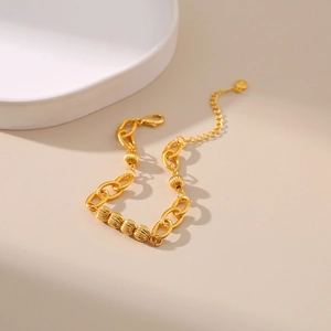 Detail of 18K gold-plated O-link bracelet with bead accents and lobster clasp