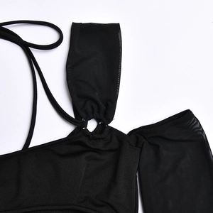 Détail de robe noire avec empiècement en mesh, fines bretelles et connecteur anneau