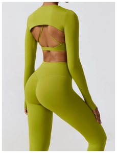 Detail of green backless yoga top with cutout design and high-waist fitness leggings