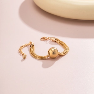 Detail view of gold multi-layer chain necklace with smooth sphere pendant and lobster clasp