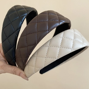 Detailed view of quilted faux leather padded headbands in black, brown, and cream white