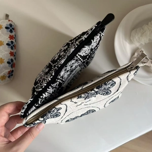 Close-up of embroidered cotton-linen cosmetic bags with flower and butterfly patterns