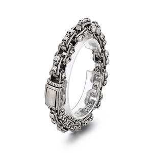 Vintage oxidized silver skull chain bracelet for men in punk rock style shown on stand