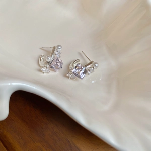 Detailed close-up of silver earrings with lavender cubic zirconia and pearl accents