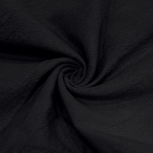 Close-up of black linen fabric with fine wrinkled texture and soft drape detail