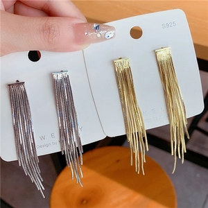Detail view of gold and silver tassel earrings with S925 silver needles on a display card