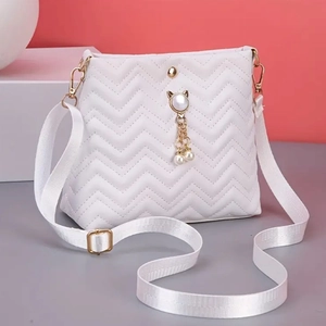 White quilted crossbody bag with wave pattern, pearl cat pendant and wide nylon strap