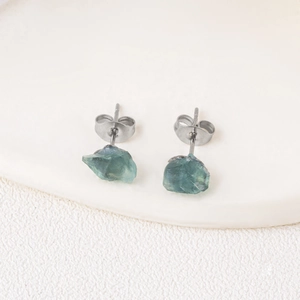 Natural green fluorite raw stone stud earrings with silver metal backing on white ceramic