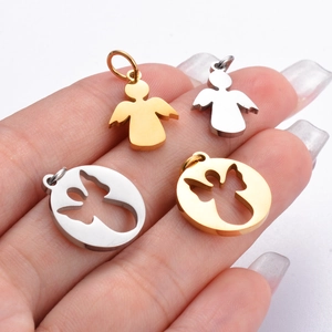 Set of four stainless steel angel pendants in gold and silver held by a model
