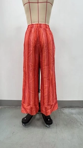 Détail du pantalon large à rayures verticales orange avec taille haute élastiquée
