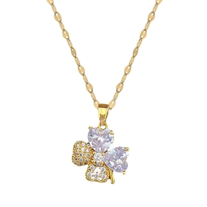 Gold titanium four-leaf clover necklace with purple heart crystals on white background