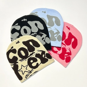 Detail shot of knitted beanies in four colors with CON letter and star jacquard pattern