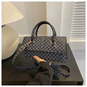Detail of retro black handbag with blue geometric prints and golden metal hardware