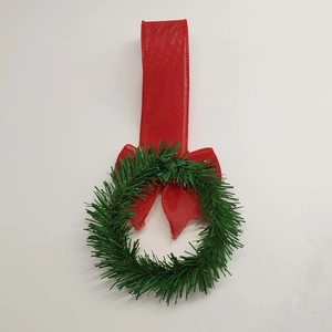 Mini Christmas wreath with green pine needles, red burlap bow, and berry pendant detail